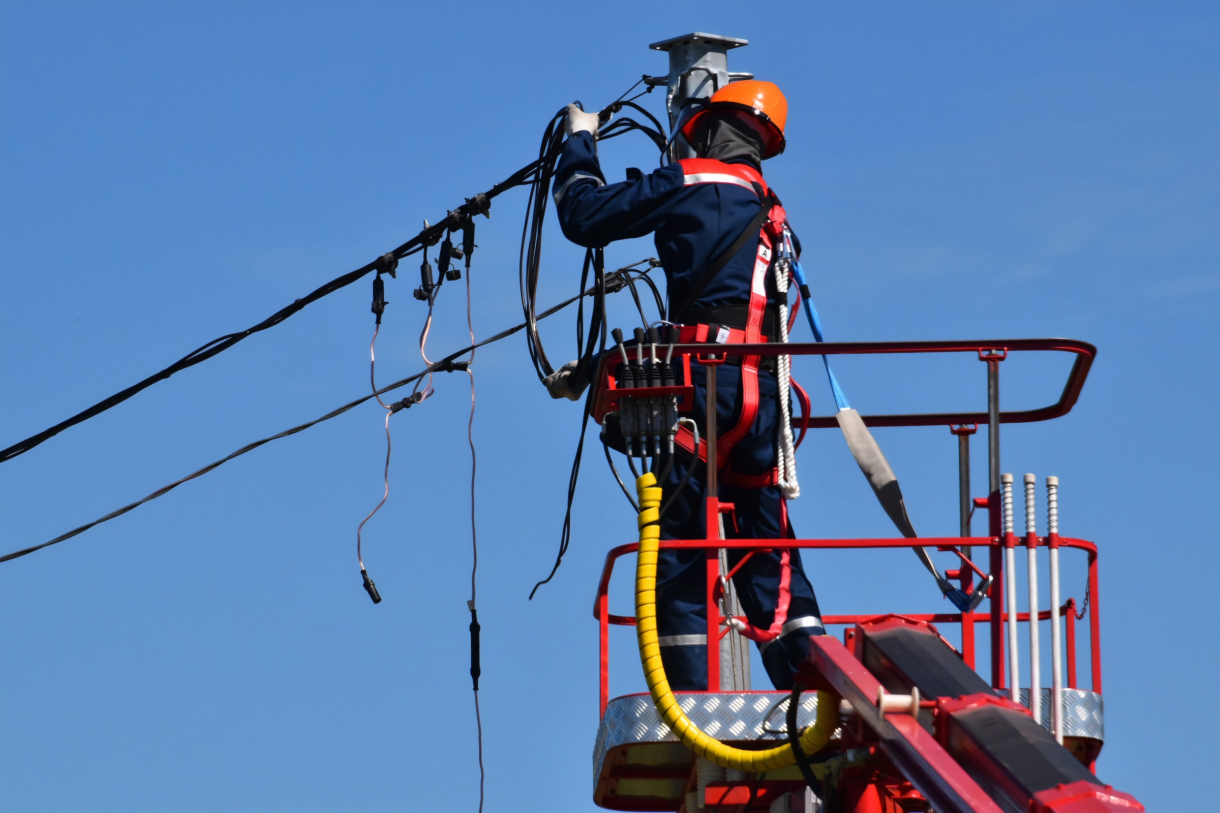 A man is performing regular electrical maintenance on a power line, ensuring its safety and reaping the associated benefits.