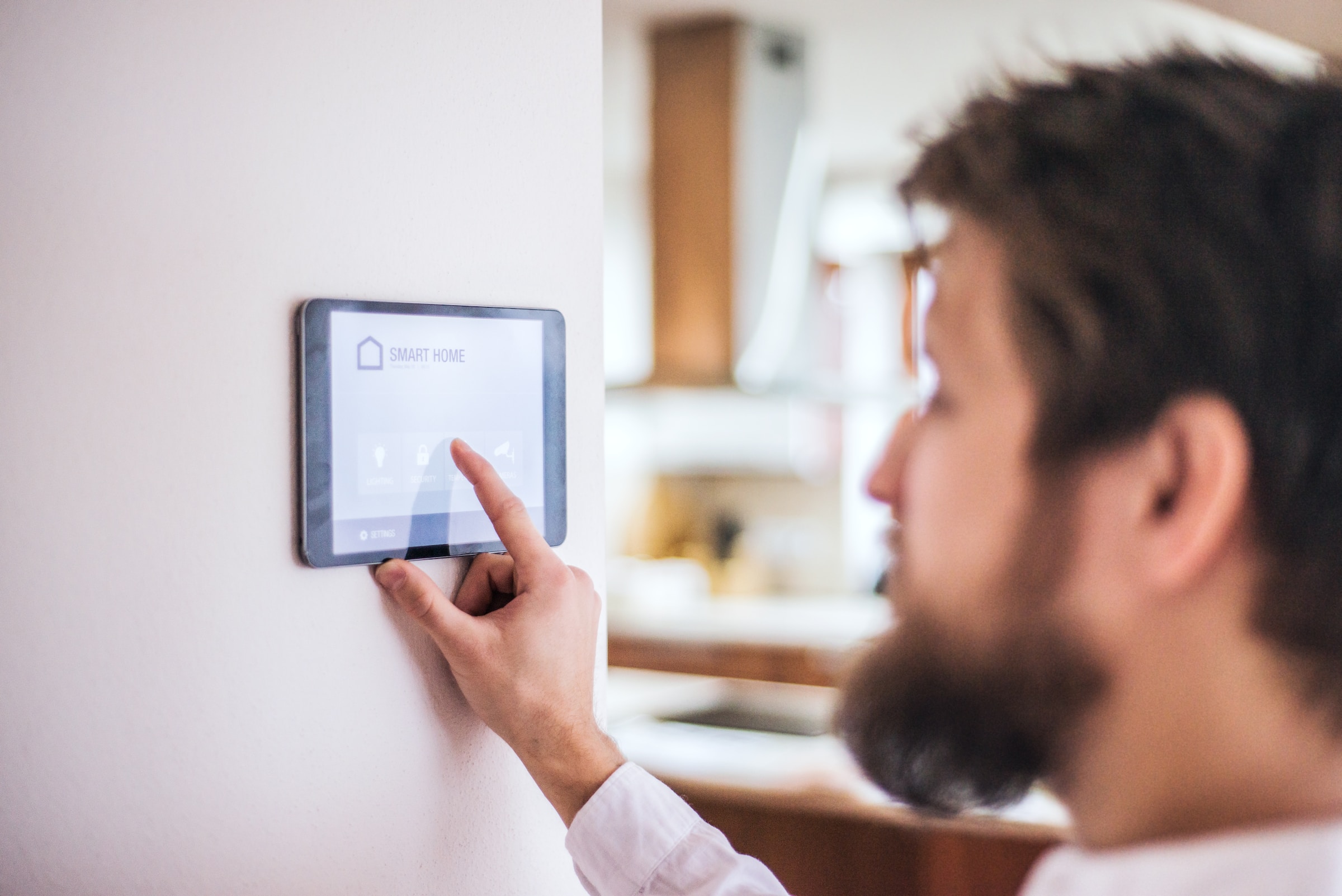 A man is using an ipad to control the heating in his home.