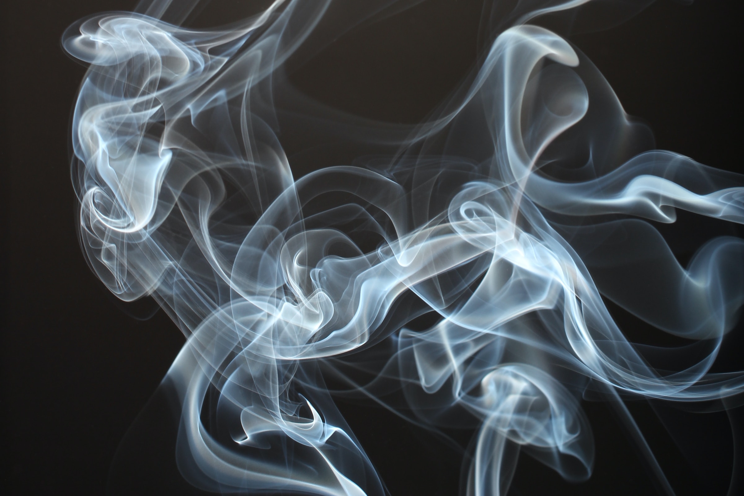 A close-up of smoke on a black background, emphasizing the importance of smoke detectors in the home.