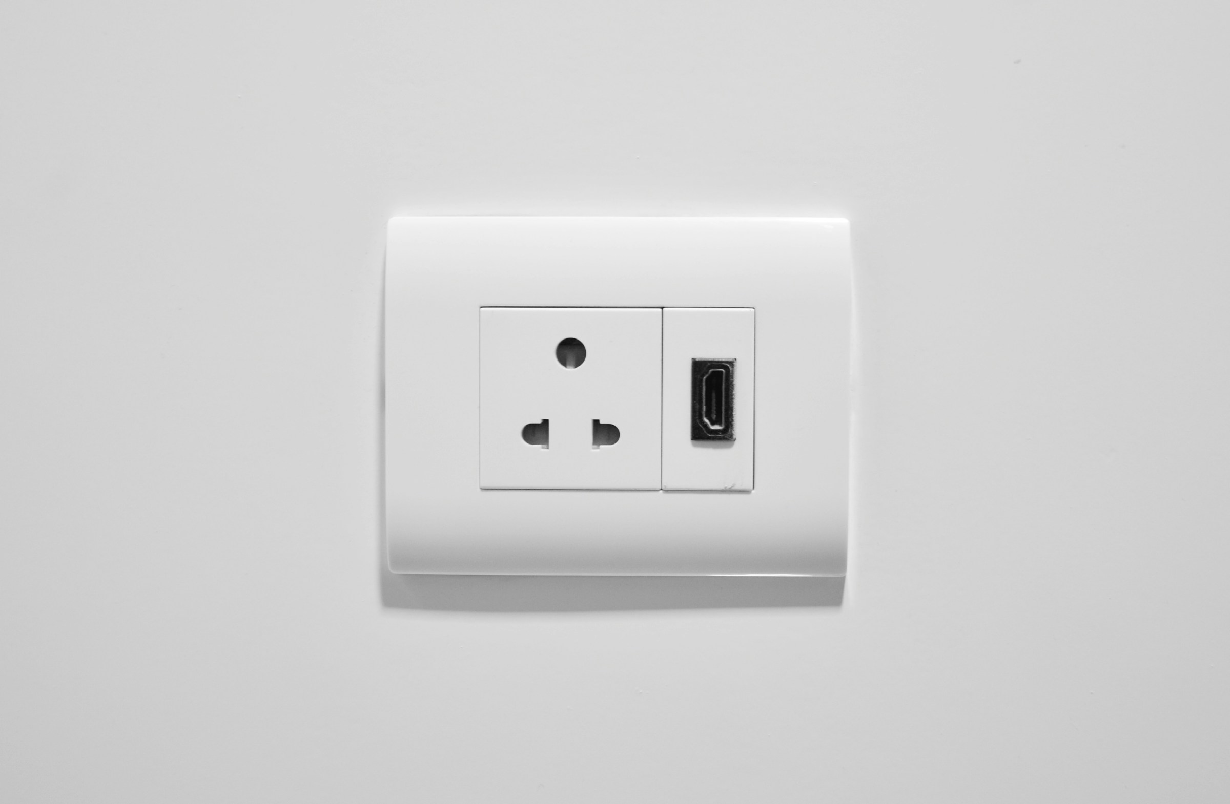 A white wall outlet with two USB ports, ensuring home safety and facilitating switchboard upgrades.